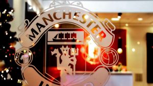 Close-up of Manchester United emblem etched on glass, showcasing iconic design indoors.